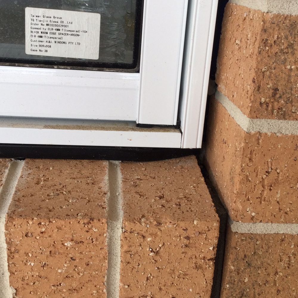 Window rubber flashing not seated between the frame and the brickwork, found during a fixing inspection in Sunbury