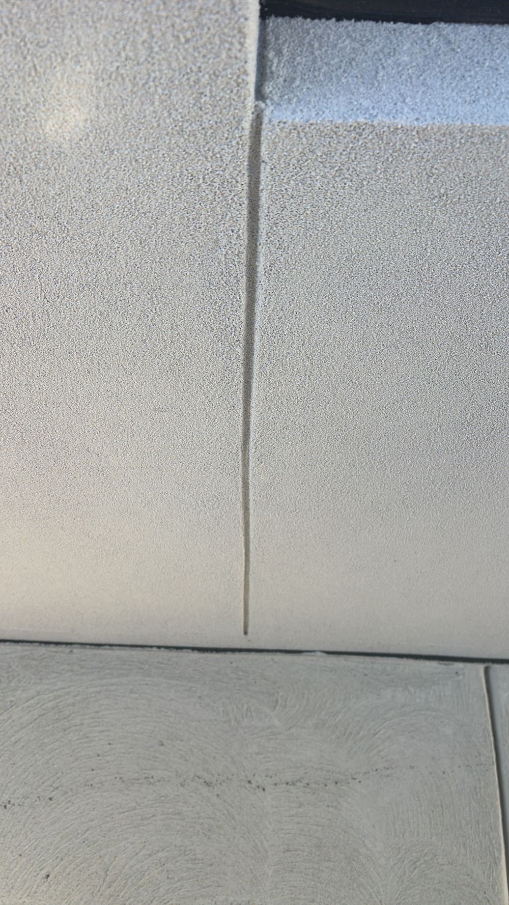 Render carried over a control joint that should stay flexible, found during a pre-handover inspection in Sunbury